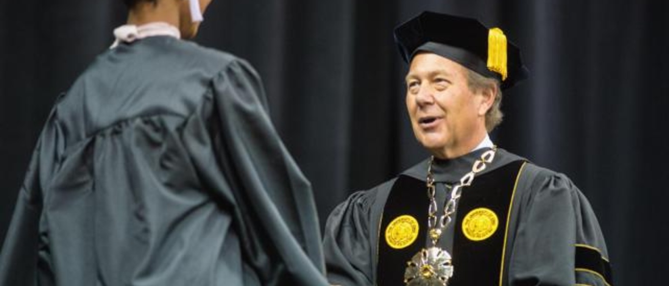 University of Iowa President Bruce Harreld congratulates a graduate at Tippie College of Business commencement ceremony. Photo courtesy of the Tippie College of Business.