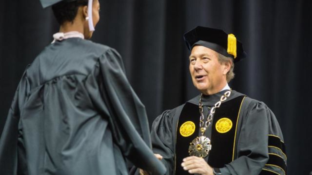 University of Iowa President Bruce Harreld congratulates a graduate at Tippie College of Business commencement ceremony. Photo courtesy of the Tippie College of Business.